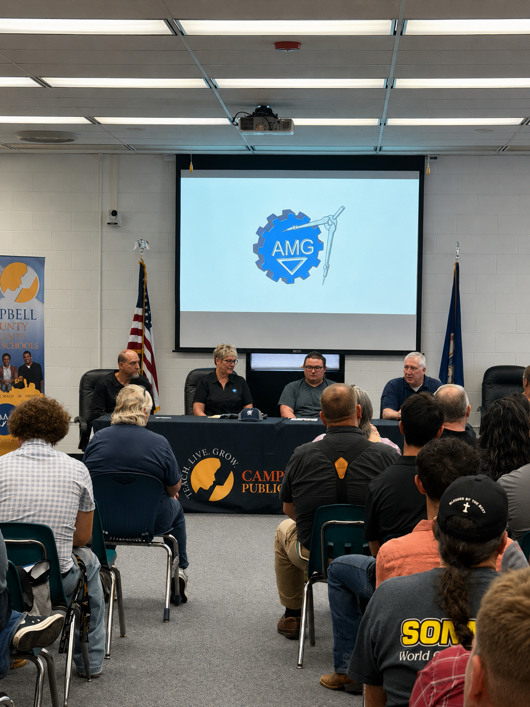 Wide room view of the Campbell County Schools 2026 CTE Signing Day event featuring AMG's projected logo and audience seating.